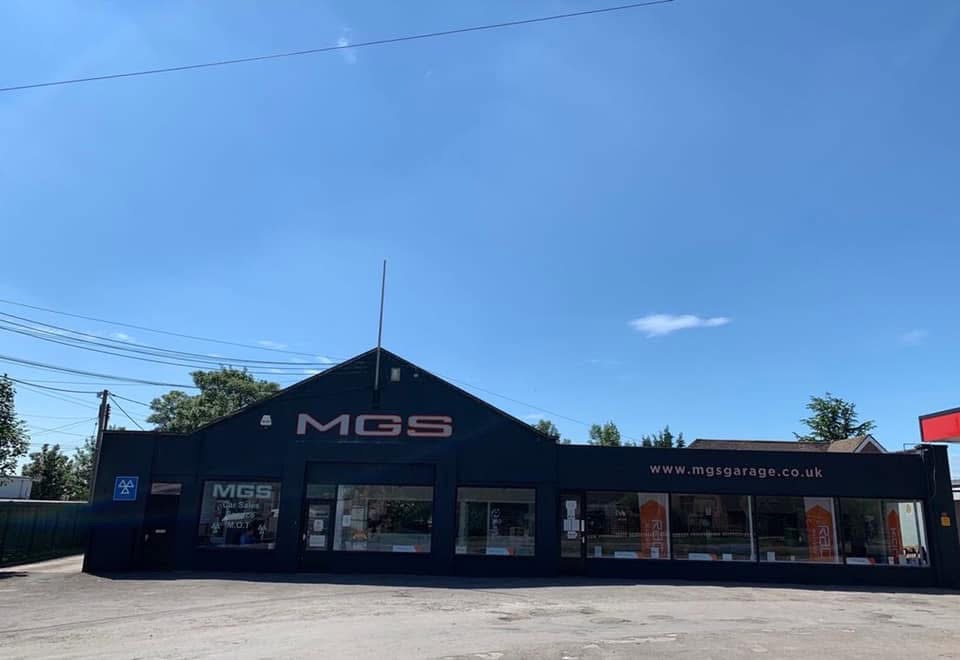 Dark navy MGS commercial garage exterior with crisp white signage and trim