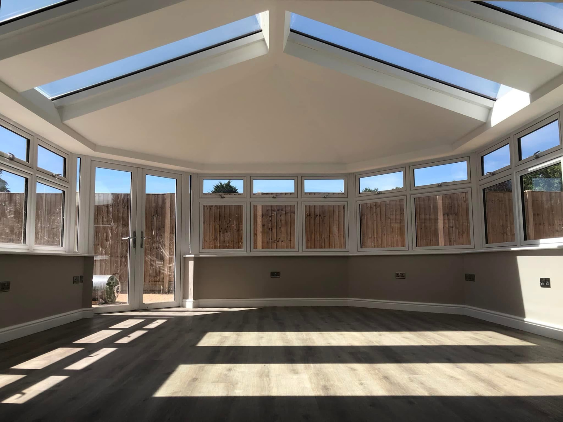 Completed conservatory with skylights, crisp white frames and warm neutral walls